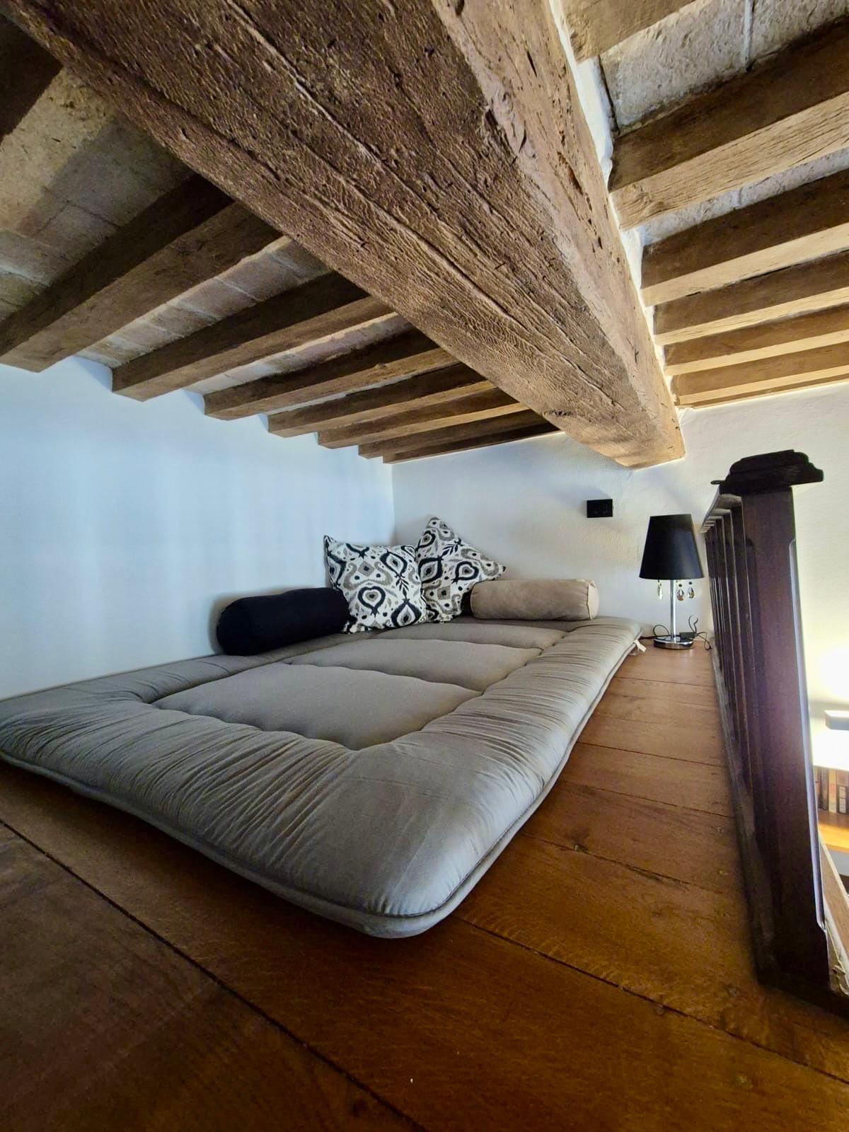 Soppalco con letto e travi a vista in legno